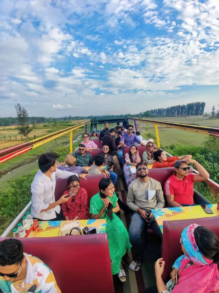 The team riding an open-top tourist bus on a company trip